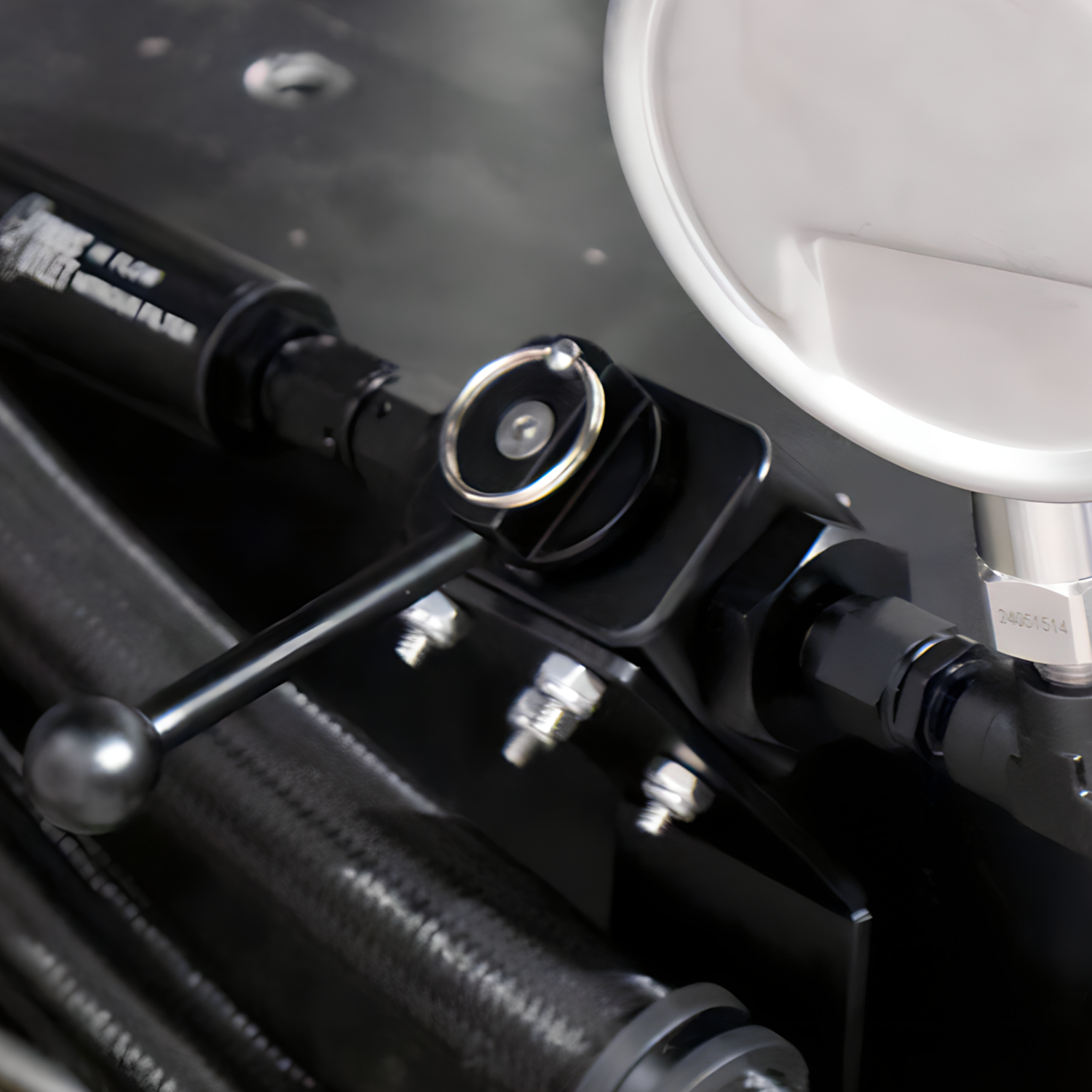 Close-up of mechanical components with a focus on black metal parts and silver bolts.